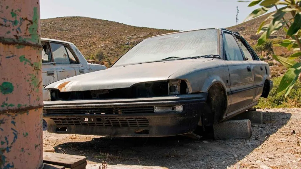 a broken car without tires mounted concrete blocks