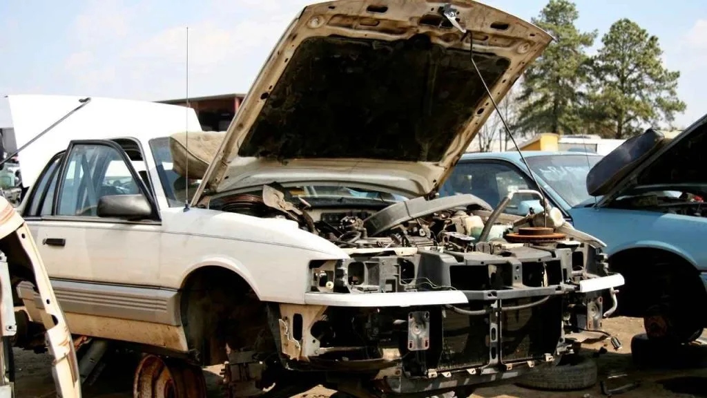 a white junk car with the front hood open